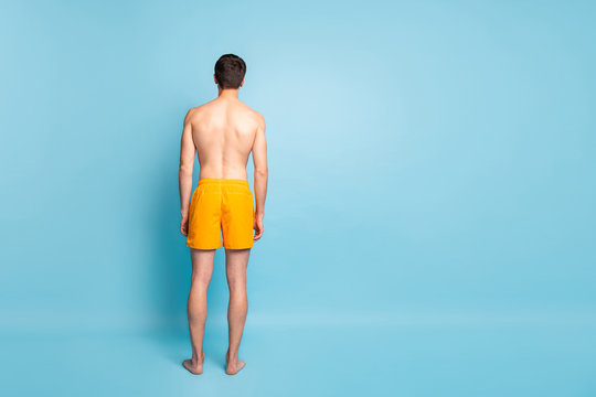 Full length body size rear back behind view of his he nice attractive young guy in swimming shorts spending vacation isolated on bright vivid shine vibrant green blue turquoise color background