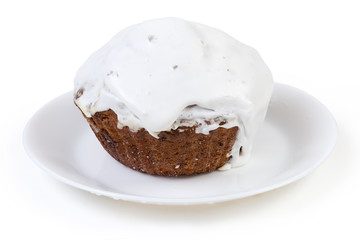 Cupcake covered with whipped egg whites icing on white dish