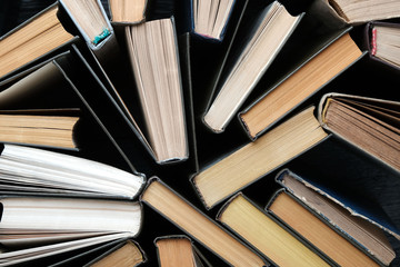 Old books on wooden vintage background, top view on binding
