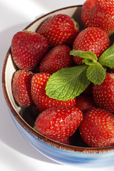 Healthy and fresh strawberries in bowl with mint