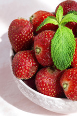 Healthy and fresh strawberries in bowl with mint