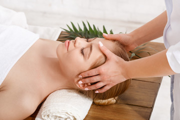 Beauty treatments. Professional doing facial massage for girl on table