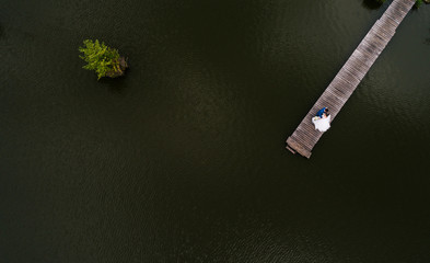 Aerial view of romantic wedding couple of groom and bride. top view of a romantic young couple on the pier. No face