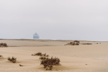 Küste Namibias - Wüste am Meer mit Containerschiff in der Ferne