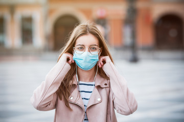 Young woman wearing medical face mask to protect herself from pollution, germs and coronavirus
