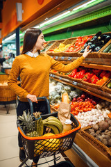 Young woman with basket in grocery store