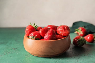 Bowl with ripe strawberry on table