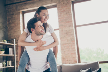 Photo of charming lady handsome guy crazy funny couple relax stay home quarantine spend time together playful mood carry piggyback meet adventures rejoicing living room indoors