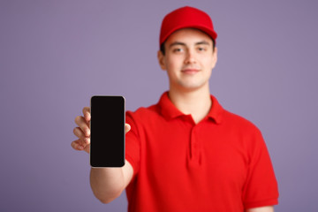 Save time on delivery. Friendly courier in uniform shows smartphone with blank screen