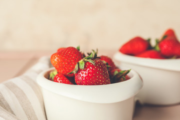 Bowls with ripe strawberry on table