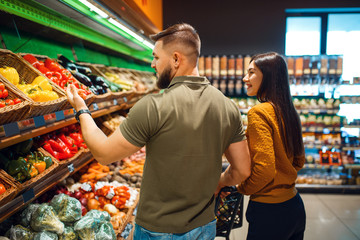 Couple with basket in grocery supermarket together
