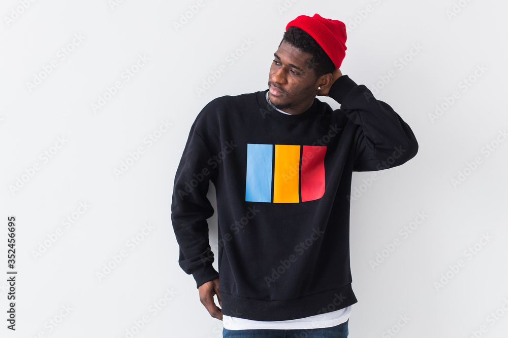 Wall mural Street fashion concept - Studio shot of young handsome African man wearing sweatshirt against white background. - Wall murals