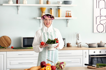 Housewife in protective costume cooking in kitchen