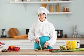 Housewife in protective costume cooking in kitchen