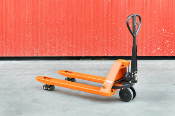 Orange hand pallet truck in the warehouse front	