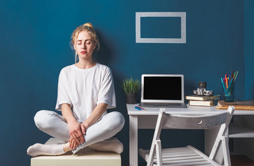 Young Attractive Girl Sitting In Lotus Position Near Desktop Work Place