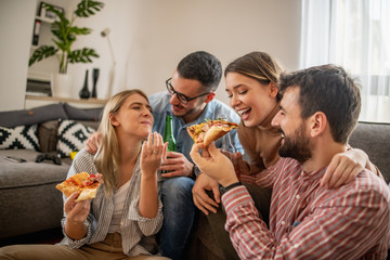 Group of friends eating pizza together at home