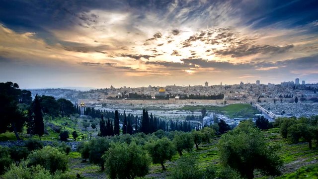 Beautiful sunset clouds over the Old City Jerusalem with Dome of the Rock, the Golden/Mercy Gate and St. Stephen's/Lions Gate; view from the Mount of Olives with olive trees in the foreground