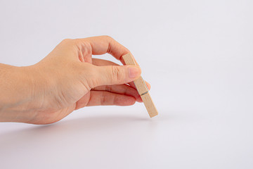 hand holding wooden clothespin isolated on white