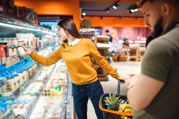 Couple choosing dairy products in grocery store