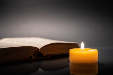 Old book and yellow candle.