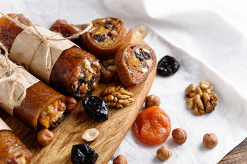 rolls with dried fruits, oriental sweets on white background, roll-up with dried apricots, prunes, nuts