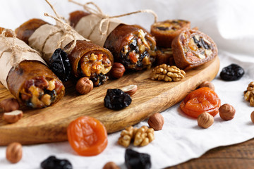 rolls with dried fruits, oriental sweets on white background, roll-up with dried apricots, prunes, walnut