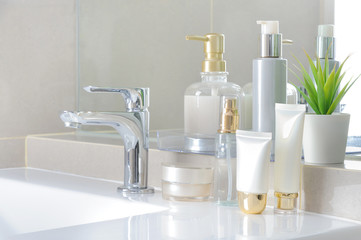 Modern bathroom design with white washbasin. Cosmetic containers on a wash basin
