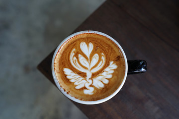 Close up Latte coffee art cup on wooden table
