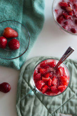 Glass with delicious strawberry panna cotta on white table  isolated background. Tasty italian...