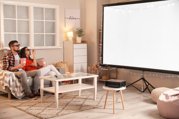 Young couple watching movie at home