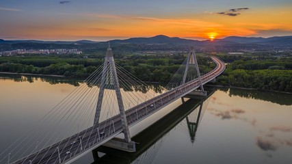 Obraz premium Budapest, Hungary - Aerial panoramic view of Megyeri suspension bridge at sunset with beautiful blue and golden sky and clouds
