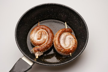 Bratwurstschnecke in Bratpfanne