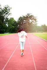 Fototapeta premium Athlete runner running on athletic track, jogger jogging in the stands of a track and field stadium for competition race, sport woman training and doing exercise outdoor