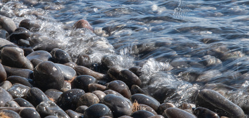 wet rocks laying in the water with sun stars