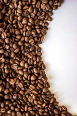 Coffee beans isolated on white background with place for text. Frame of coffee beans on white background. Closeup of coffee beans on plain paper.