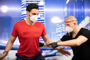 Joven entrenando con los EPIs colocados (equipos de protección personal), consistente en guantes...