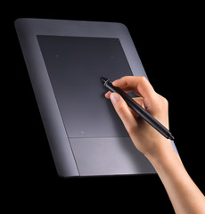 Hand holding digital graphic pen and drawing graphic tablet isolated on black