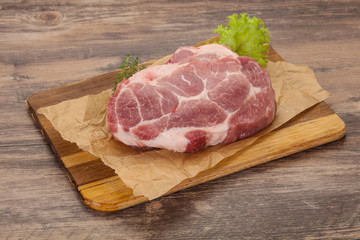 Raw pork steak over wooden board