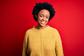 Young beautiful African American afro woman with curly hair wearing casual yellow sweater with a happy and cool smile on face. Lucky person.