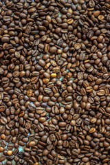Fresh coffee beans brown seed texture background full wallpaper. Coffee beans roasted for the background. Mixture of different kinds of coffee beans. Close up.