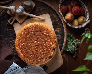 Old house, homemade food. Baked homemade bread, young garlic on a wooden chair, a basket with apples