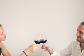Young lovers with wine glasses in the restaurant for the day of love. Cheers! Hands holding wine glass. White background for copy space.  Celebration, Wedding concept. Image