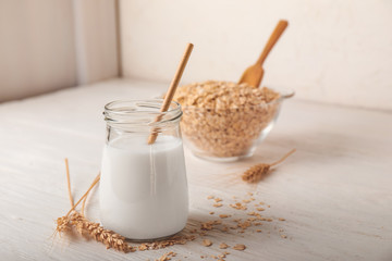 Jar of tasty oat milk on white table