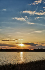 Vertical panoramic photo of beautiful blue sunset sky with a yellow sun that shines through the clouds