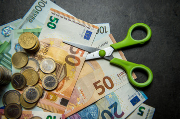 concept image with euro money cutting with scissors because of the financial crisis due to...