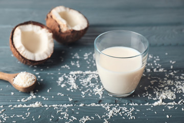 Glass of tasty coconut milk on table