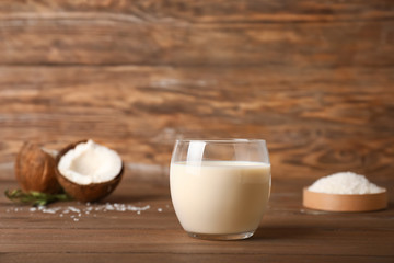 Glass of tasty coconut milk on table