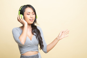 Pretty asian girl listening music with her headphones.