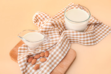 Tasty almond milk on color background